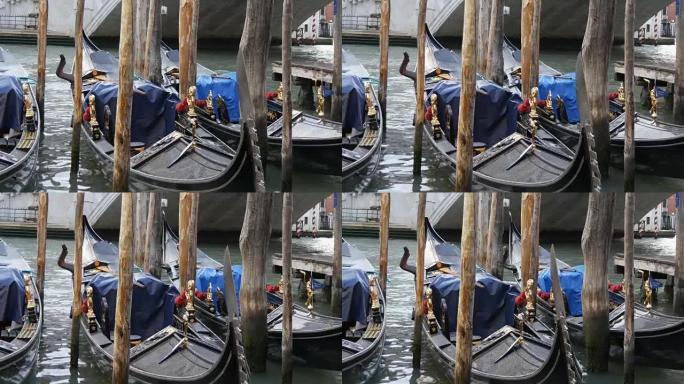 美丽的黑色吊船，镀金的雕像停在世界著名的里亚托桥下