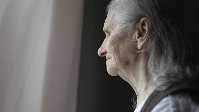 灰色头发的悲伤老妇人的特写脸。