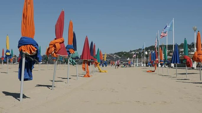 著名电影节城市的五颜六色的阳伞，白天在海滩上防晒，缓慢倾斜的镜头