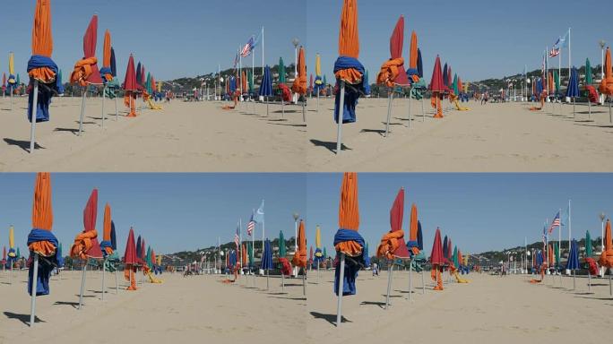 著名电影节城市的五颜六色的阳伞，白天在海滩上防晒，缓慢倾斜的镜头