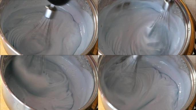 在金属碗中形成郁郁葱葱的奶油蛋ust浇头的过程，该金属碗位于自动搅拌机中。
