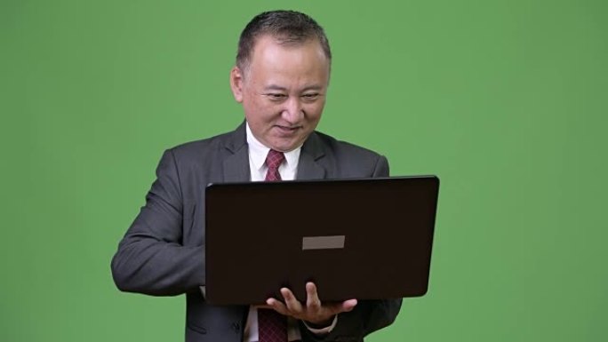 成熟的日本商人使用笔记本电脑
