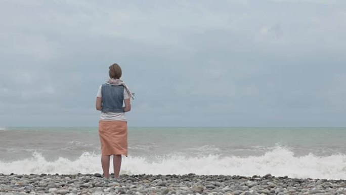 海滩上的年轻女孩看着大海的高浪 -- 佐治亚州
