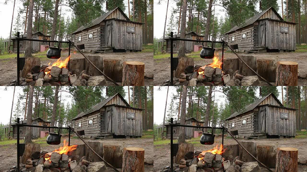 森林小屋附近的篝火上的水壶