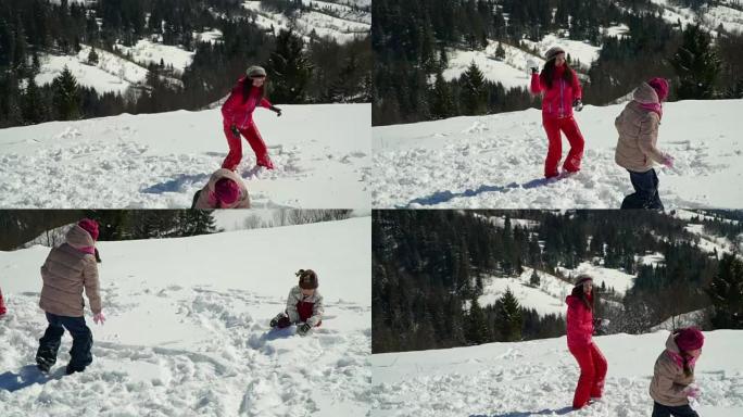 快乐的家庭在冬天在山上的白雪皑皑的森林里玩耍。妈妈和她的两个孩子扔雪球。他们在笑。