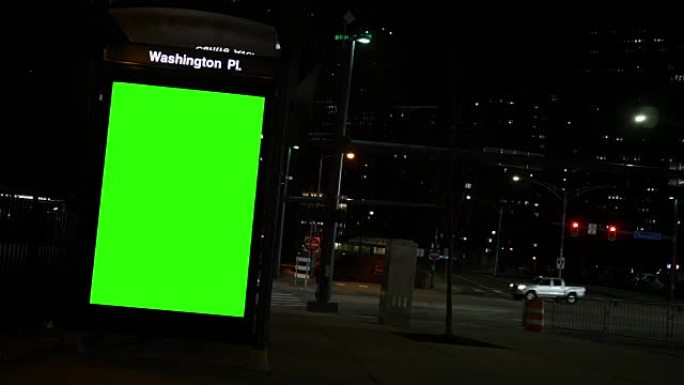 夜间市区公交车站的通用绿屏广告标牌