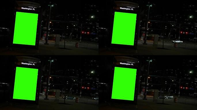 夜间市区公交车站的通用绿屏广告标牌