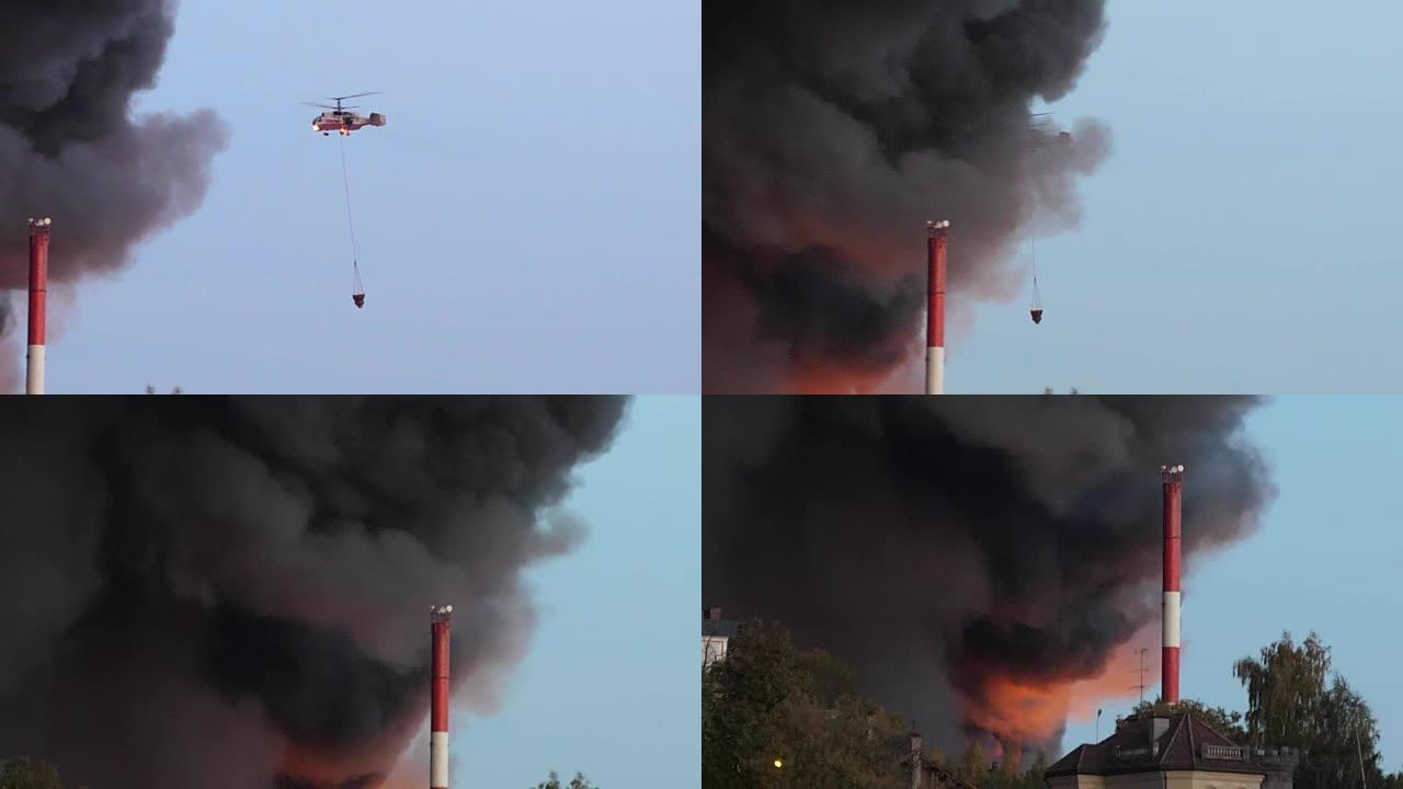 直升机正在扑灭这座城市的大火。用空气中的水灭火。直升机火焰和烟雾。一队消防员坚守。用软管冲洗并扑灭房