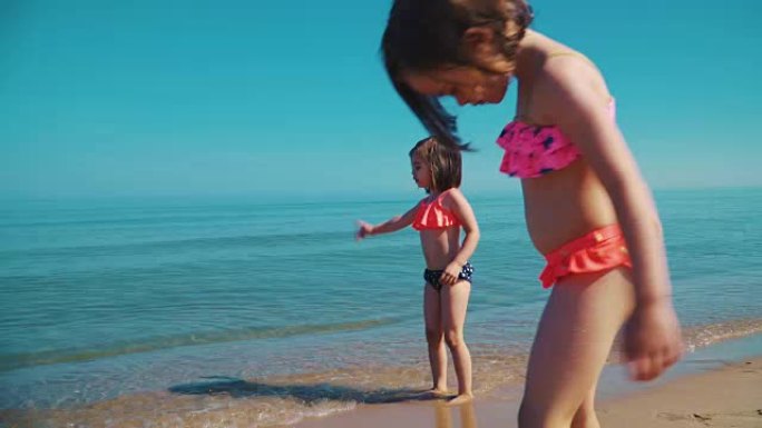 两个穿着泳衣的可爱女孩在海里玩耍