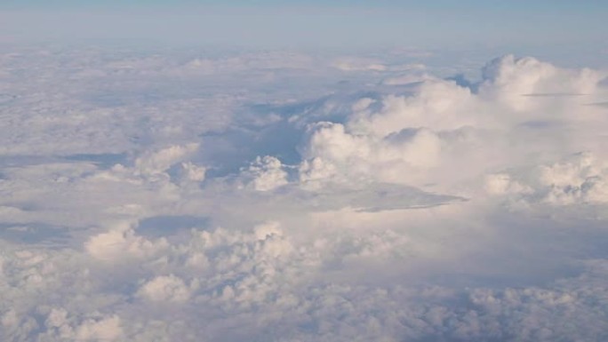 从飞机高空飞行的白色蓬松云上晴朗天空的美丽鸟瞰图