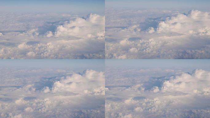 从飞机高空飞行的白色蓬松云上晴朗天空的美丽鸟瞰图