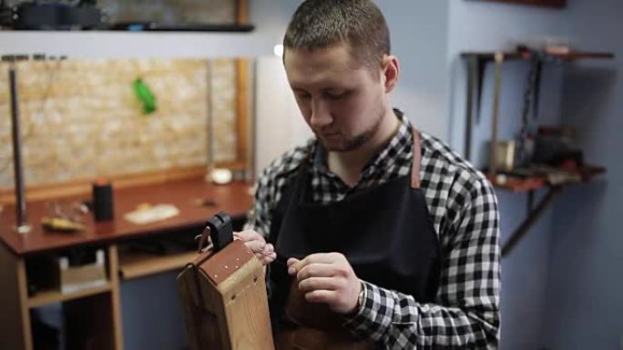 男性坦纳 (Tanner) 在他的工作室里从事皮带的生产。皮具工匠在他的车间工作