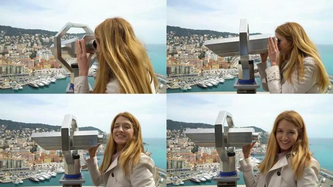 年轻女子在法国尼斯的风景名胜中通过固定的双筒望远镜观看