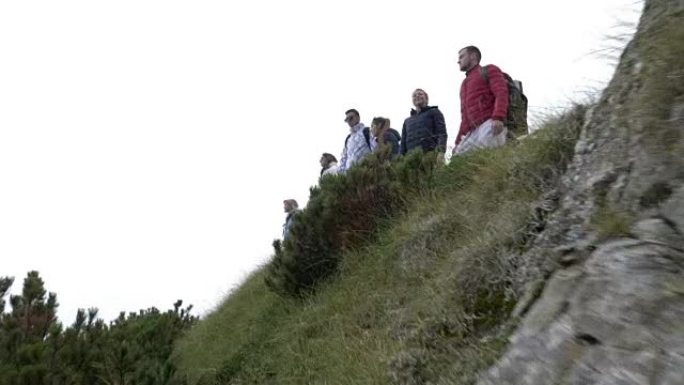 团队建设中的年轻团队业务同事庆祝成就在山峰边缘崛起成功人士的概念