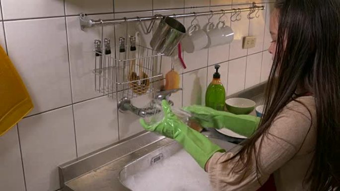 亚裔美国女孩开心地做洗碗家务，洗玻璃