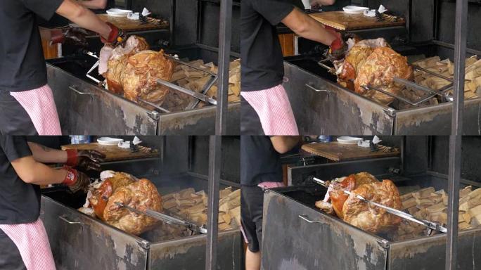 在明火上方的吐口水上准备的大块肉烤猪腿。捷克共和国布拉格的街头美食