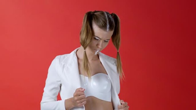 穿着白色夹克的时装模特展示塑料胸罩。时尚视频。
