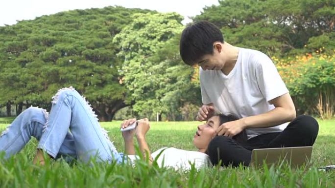 快乐的亚洲夫妇在大学公园玩得开心。