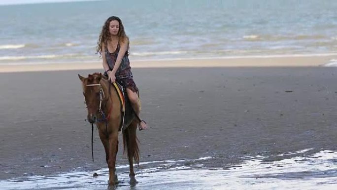 年轻女子在海边骑马