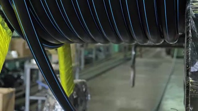 轧辊螺纹盘管。塑料水管制造厂。利用水和气压在机床上制作塑料管的过程。
