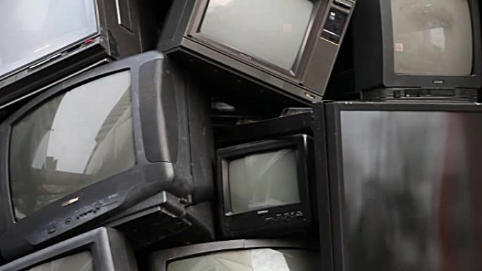 旧电视电子垃圾，垃圾，垃圾。回收概念和环境主题博览会中的破碎电视堆叠节目。有利于背景标题，结束信用