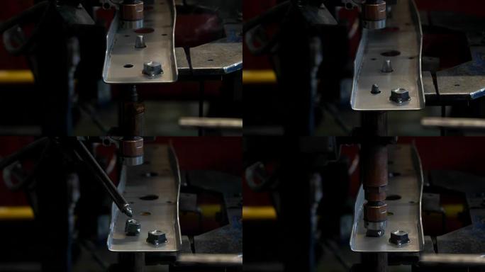 自动点焊机正在将螺母焊接到钢制零件上