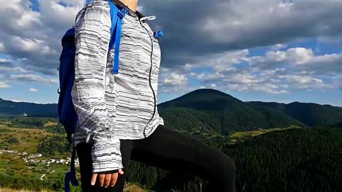 女人背着背包在山顶看日落，徒步女孩庆祝生活，风景优美的自然景观，享受假期旅行冒险