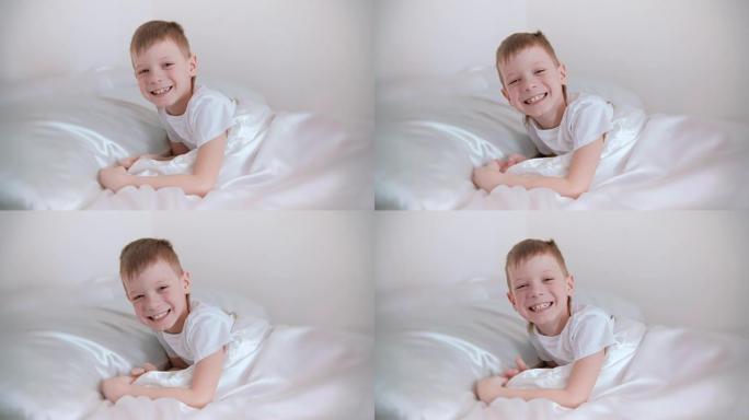 七岁的男孩刚醒来，躺在床上大笑。
