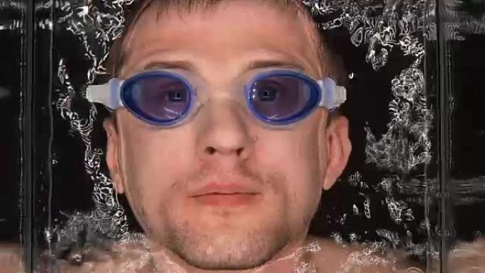 戴眼镜的人低下头进入水中，屏住呼吸，用空气吹泡泡
