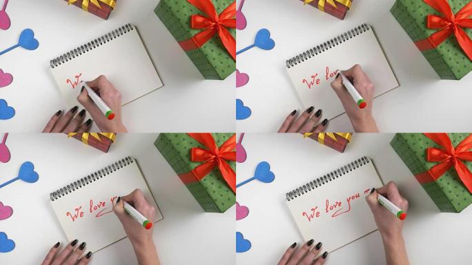情人节，插图，女人的手写在笔记本上，我们爱你妈妈。60 fps