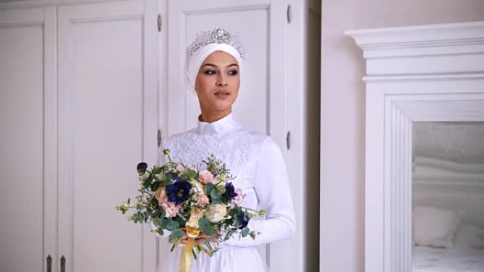 美丽的穆斯林新娘，穿着白色头饰的婚纱化妆