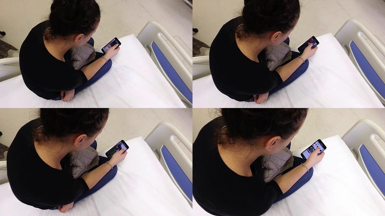 美丽的女性患者在医院的病床上使用智能手机冲浪社交网络。外科手术后等待出院
