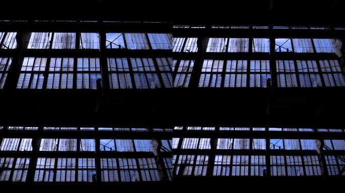 旧空楼的大玻璃墙，有许多窗户，相机正在黑暗的空间中移回
