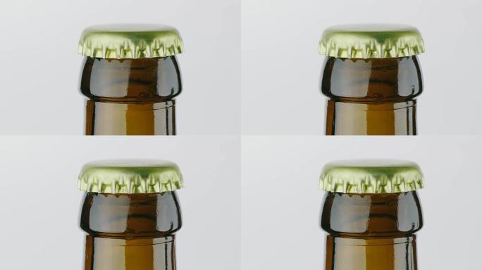 特写镜头: 一瓶啤酒的脖子上盖着金属盖。在白色背景上