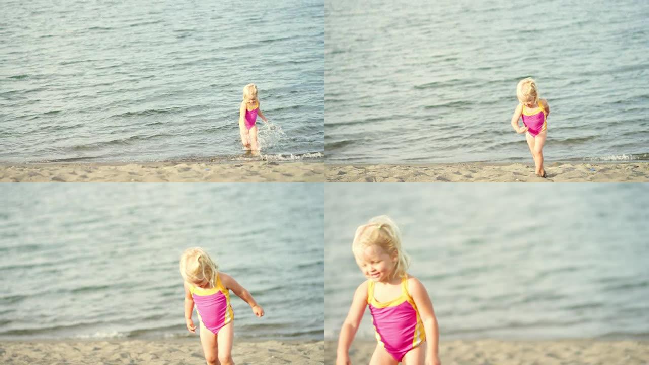 一个蹒跚学步的孩子从水里跑到海滩上