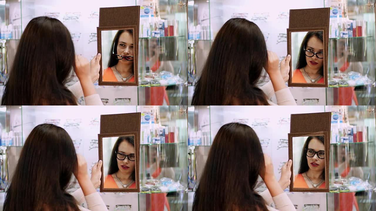 年轻女子在眼镜店的镜子里检查她的新眼镜。眼镜店戴眼镜的年轻女子。眼镜店戴眼镜的美女