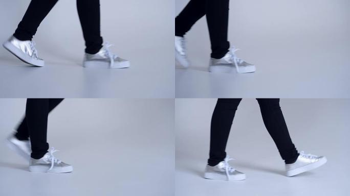 穿着运动鞋的腿在白色背景上行走