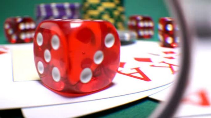 游戏桌上的红色骨头用美元和筹码通过镜头棱镜玩