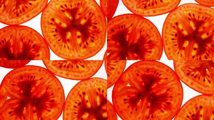 切成薄片的新鲜红番茄的绝佳俯视图，喜欢苹果，平躺特写，顺时针旋转，中心向下。