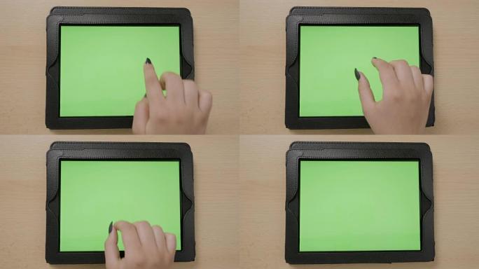年轻女性双手触摸平板电脑绿屏浏览放大和缩小的俯视图