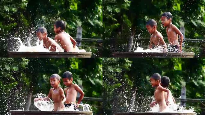 两个孩子在泰国农村的水盆里玩耍。(手持相机)