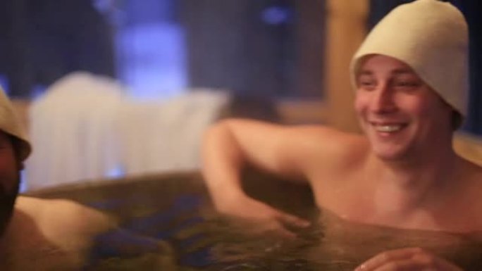 微笑快乐的男人在户外冬季热水浴缸洗澡
