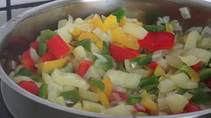 在煎锅上炸胡椒。在煎锅上炸五颜六色的蔬菜。