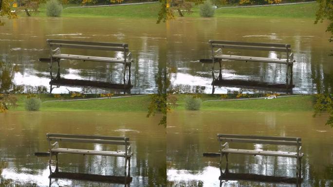 秋雨过后，白色公园长椅在河水泛滥的洪水中