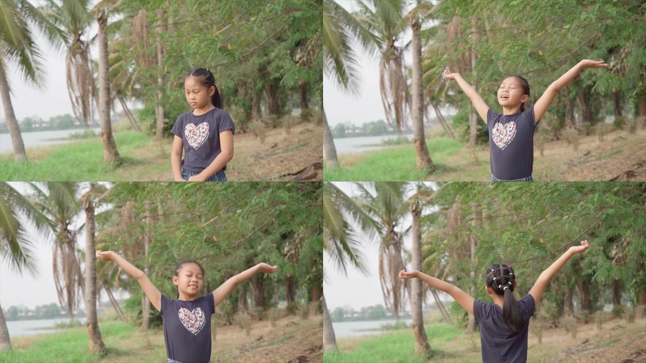 亚洲女孩在大自然中休息和享受，手臂伸出，树区