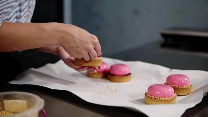 烹饪、烘焙和糖果概念 -- 厨师在厨房用金色洒水装饰镜面釉蛋糕