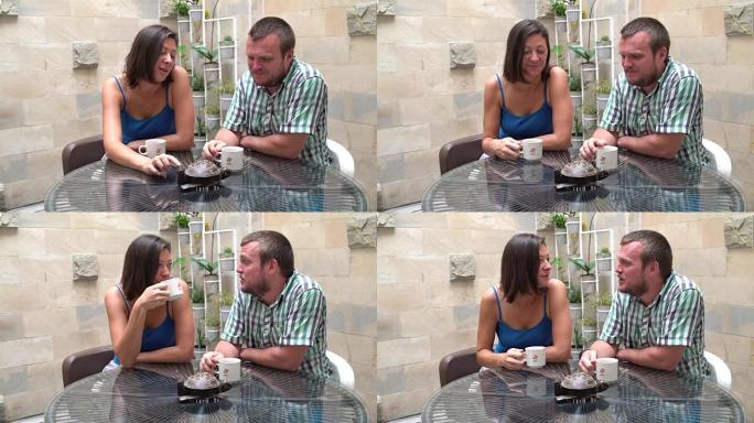 一个女人和一个男人坐在桌子旁喝茶