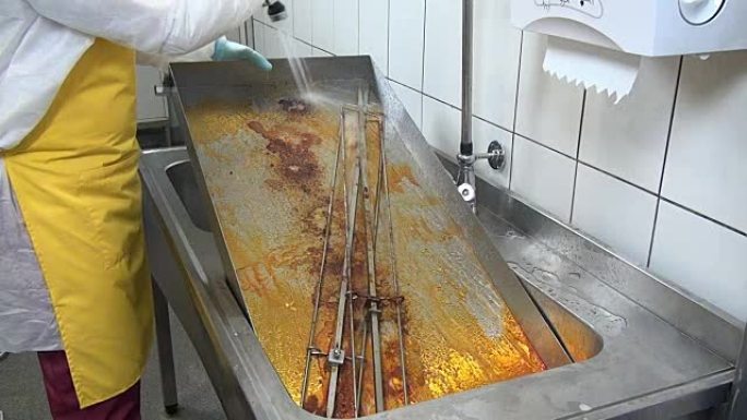 工人的手清理工业烤架上的脂肪。