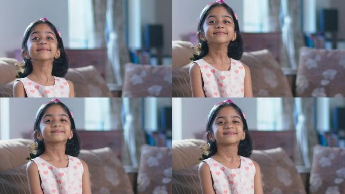 年轻快乐的印度小女孩微笑着看着室内的相机。