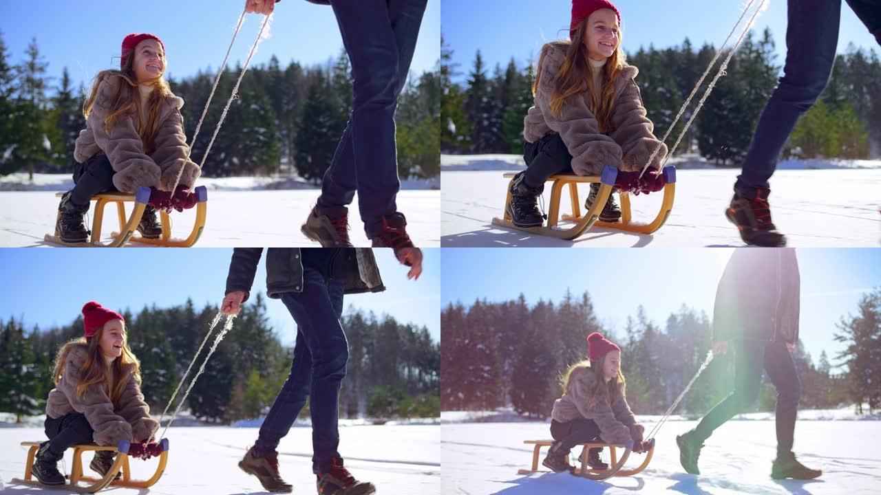年轻女孩被拉在雪橇上穿过冰冻的湖面，微笑着